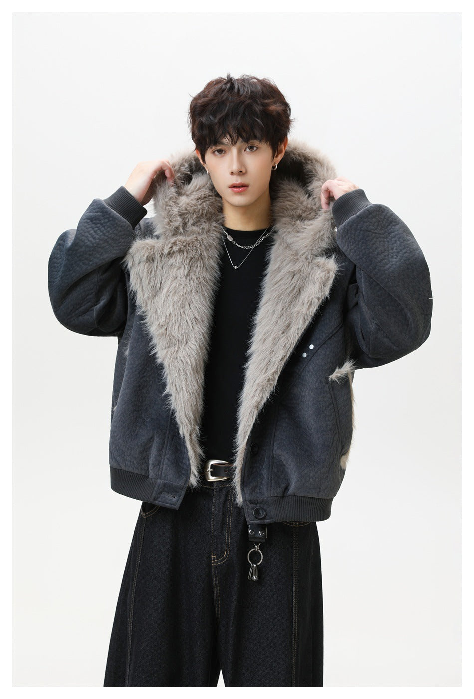 Model wearing dark gray jacket with hood up, fluffy fur-like lining, ribbed cuffs and hem, and dark wide-leg jeans