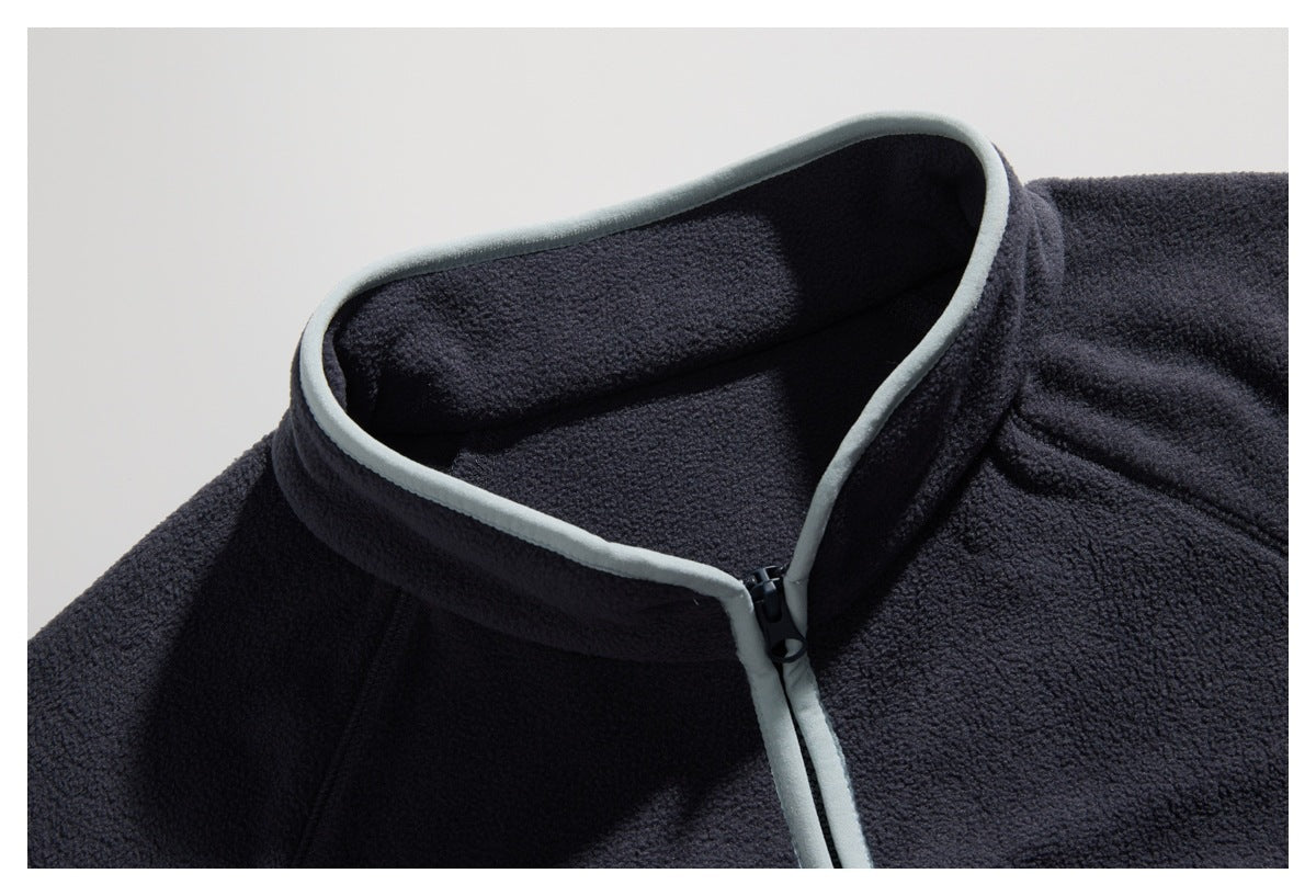 Close-up of a dark navy fleece jacket collar with pale gray piping and a front zipper.