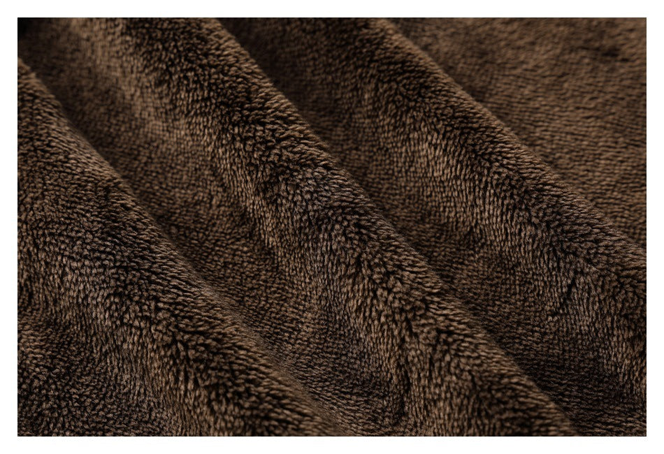Macro view of the dark brown, textured plush fabric.