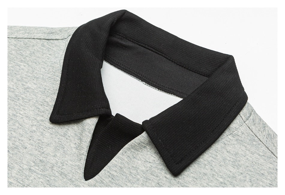 Close-up of a black pointed collar against heather-gray fabric, showing the neckline and collar stitching.