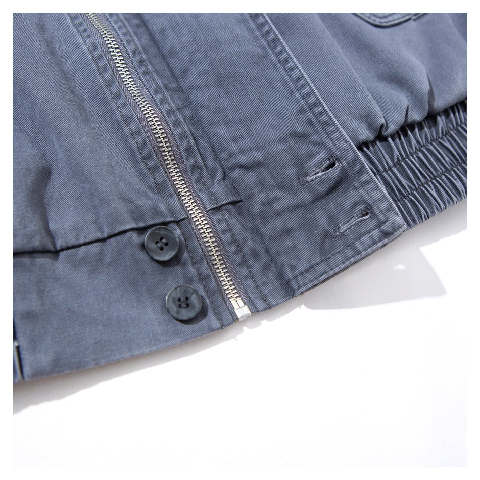 Close-up of the jacket front zipper, dark buttons, stitched placket, and gathered elastic hem.