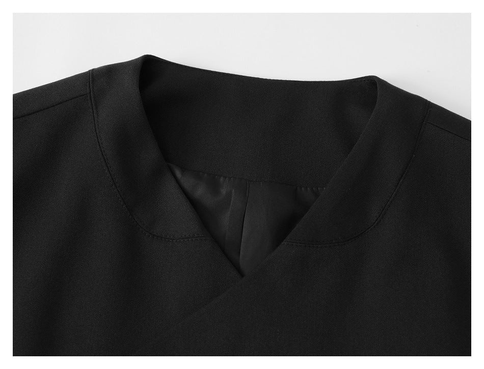 Close-up of a black jacket's notched wrap neckline and inner lining.