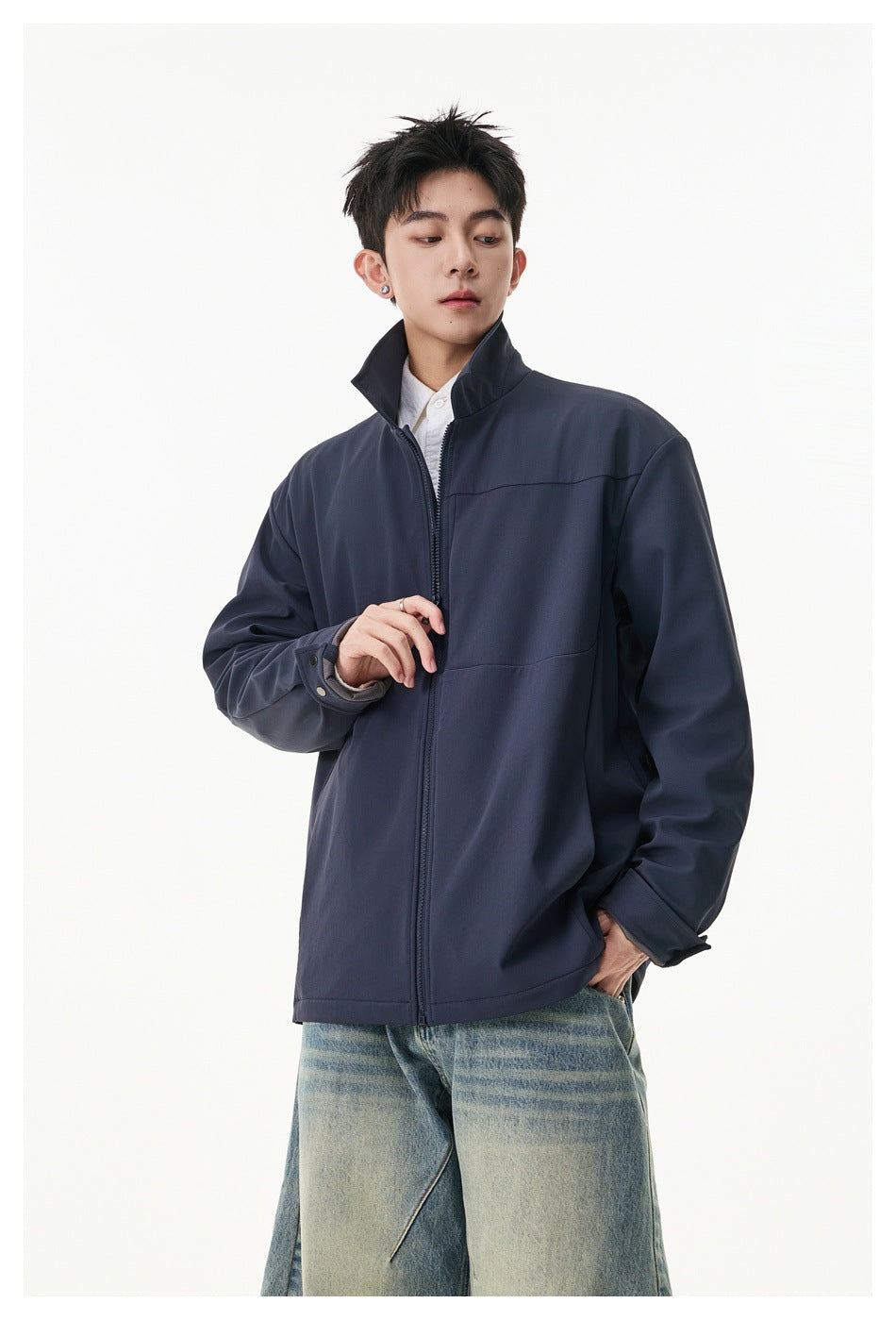 Model wearing a dark navy zip-front jacket with an upturned collar, chest panel and adjustable cuffs.