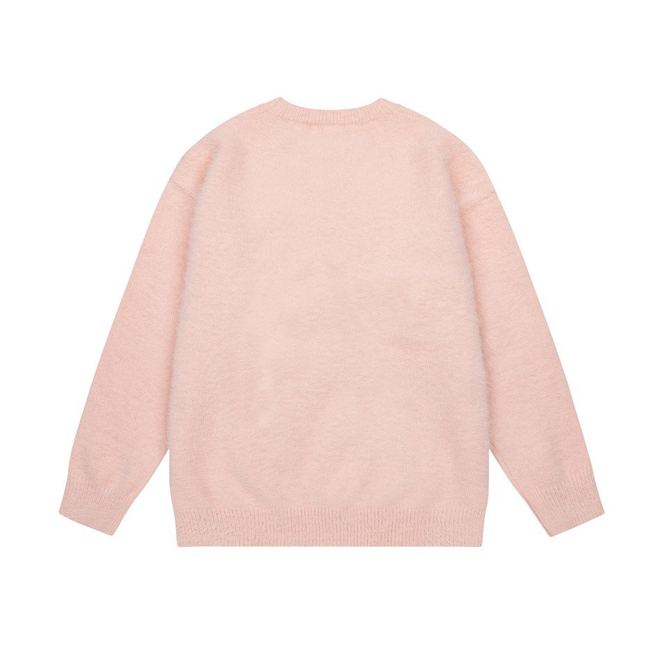 Back view of a plain pale-pink crew-neck sweater with long sleeves and ribbed cuffs and hem, laid flat.