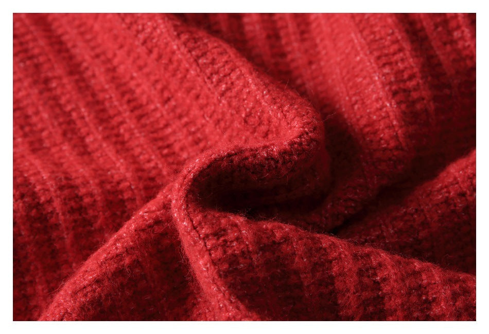Macro view of the red sweater's textured knit stitches and folded edge.