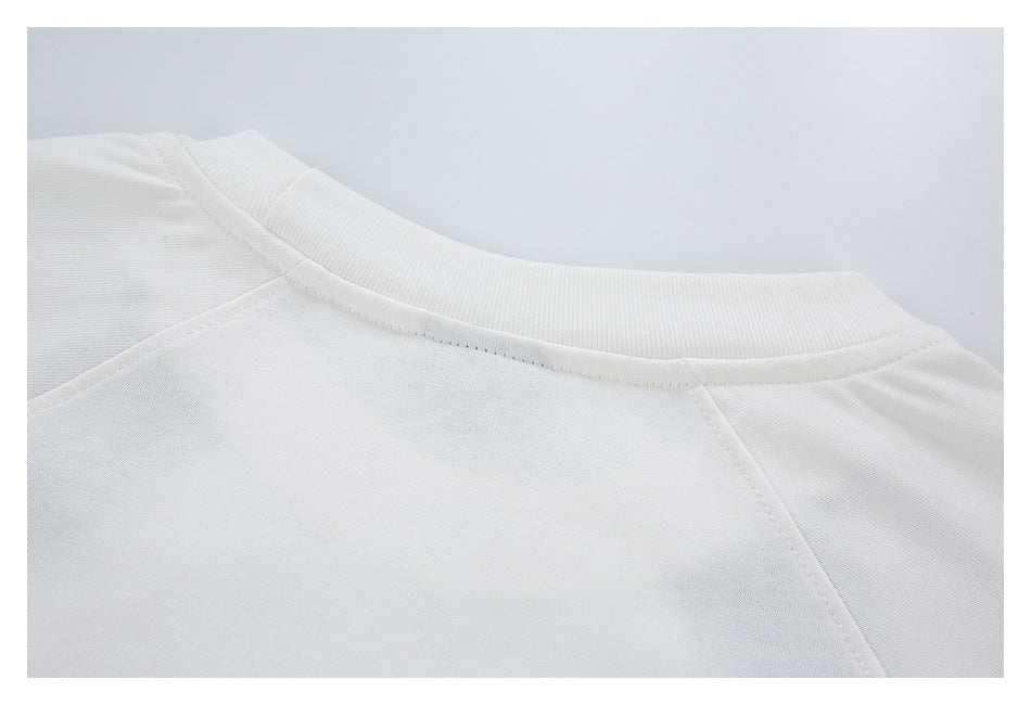 Close-up of a white top's rounded neckline and shoulder seams.