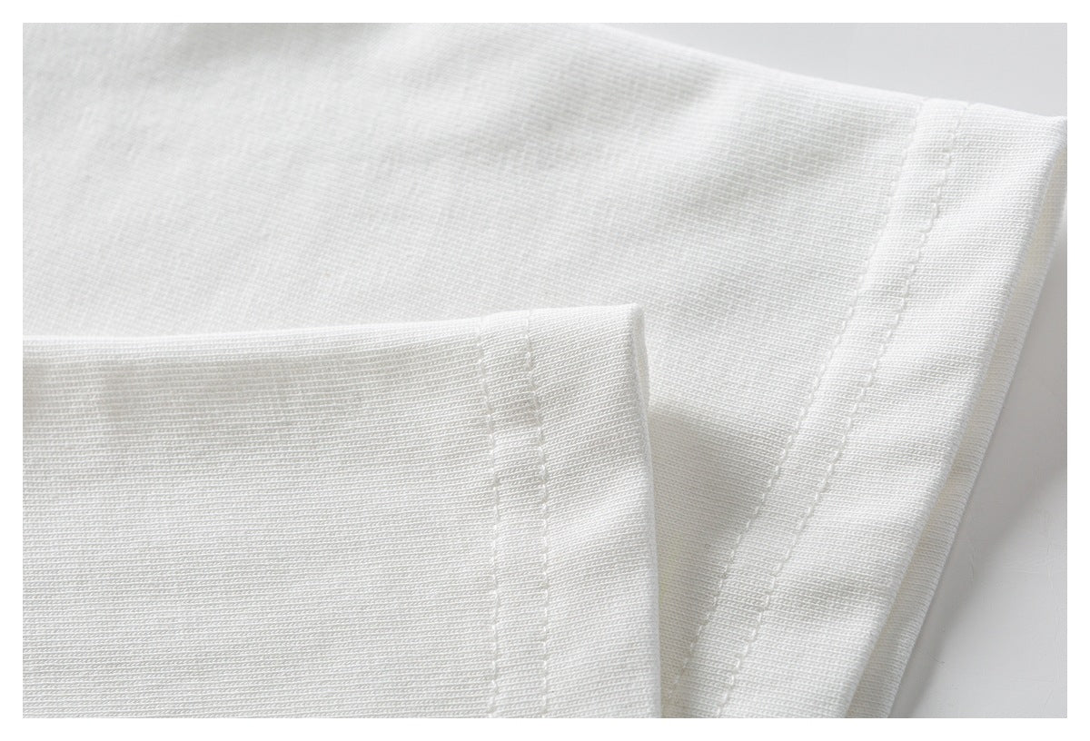 Close-up of white garment fabric showing a folded edge and parallel stitching.