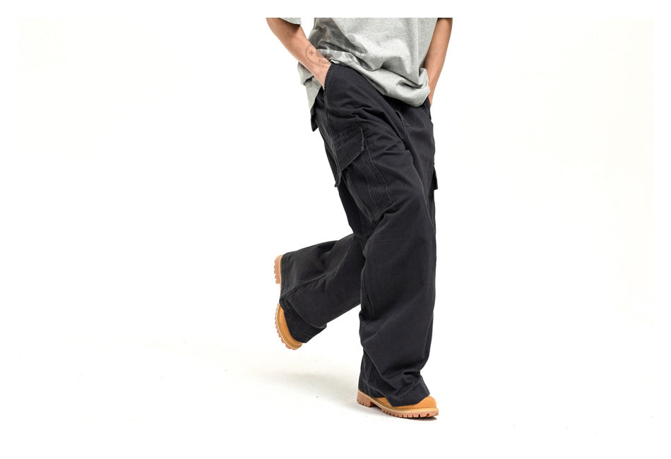 Cropped model wearing loose black cargo pants with large side pockets and tan-soled shoes.