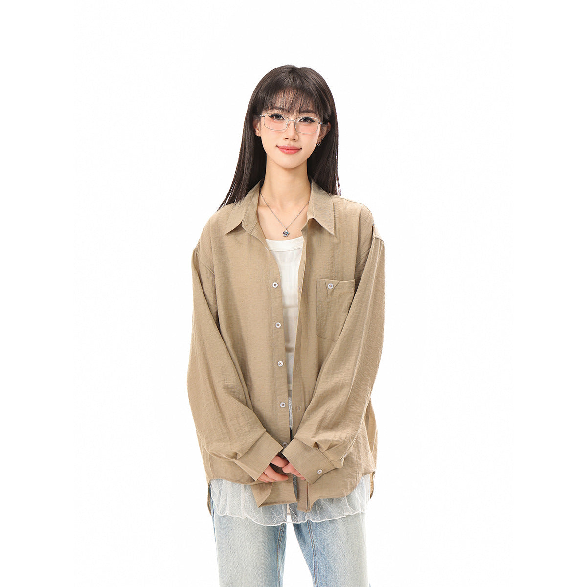 Model wearing an oversized taupe button-up shirt over a white top, with light blue jeans.