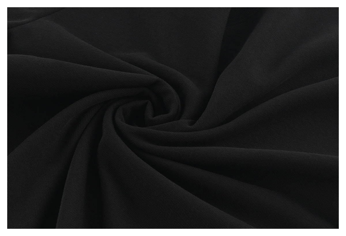 Close-up of black fabric gathered into folds, showing its surface texture.