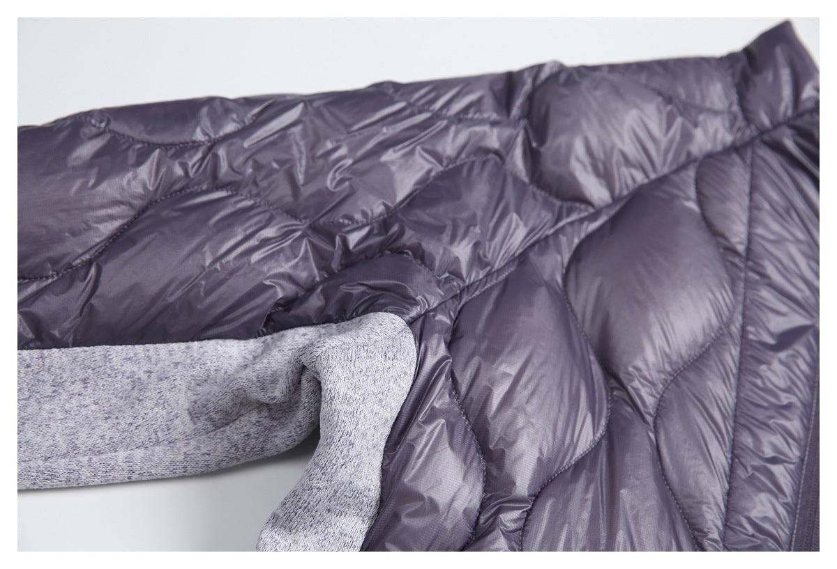 Close-up of a jacket’s dark plum quilted lining beside a light gray marled knit sleeve.