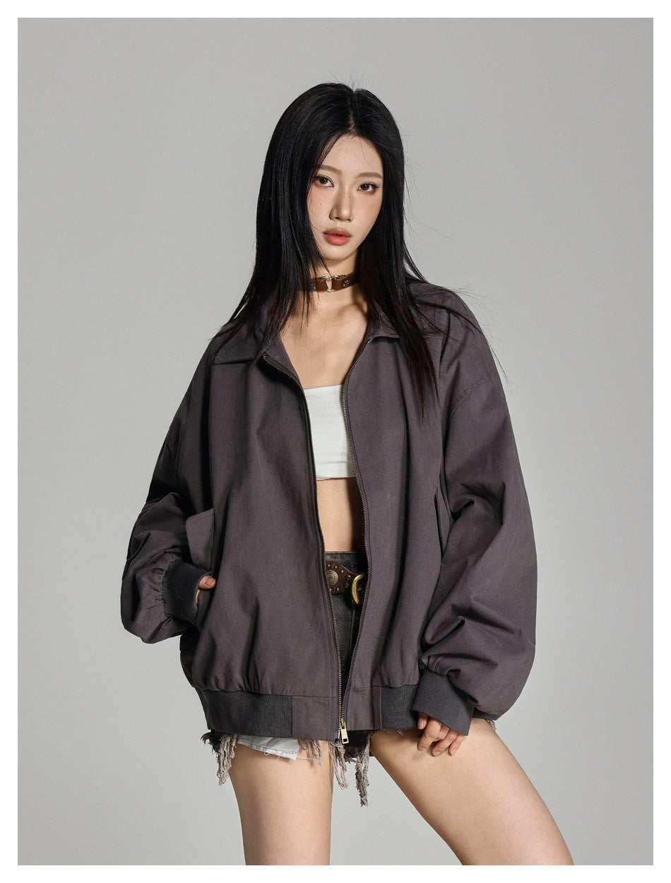 Close-up of a model in an open oversized gray zip jacket with collar, ribbed cuffs and hem, over a white top