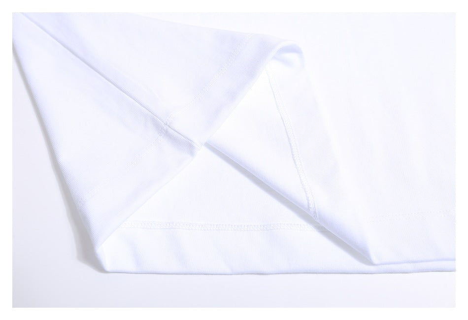 Close-up of the white T-shirt’s sleeve, side seam, and bottom hem stitching.