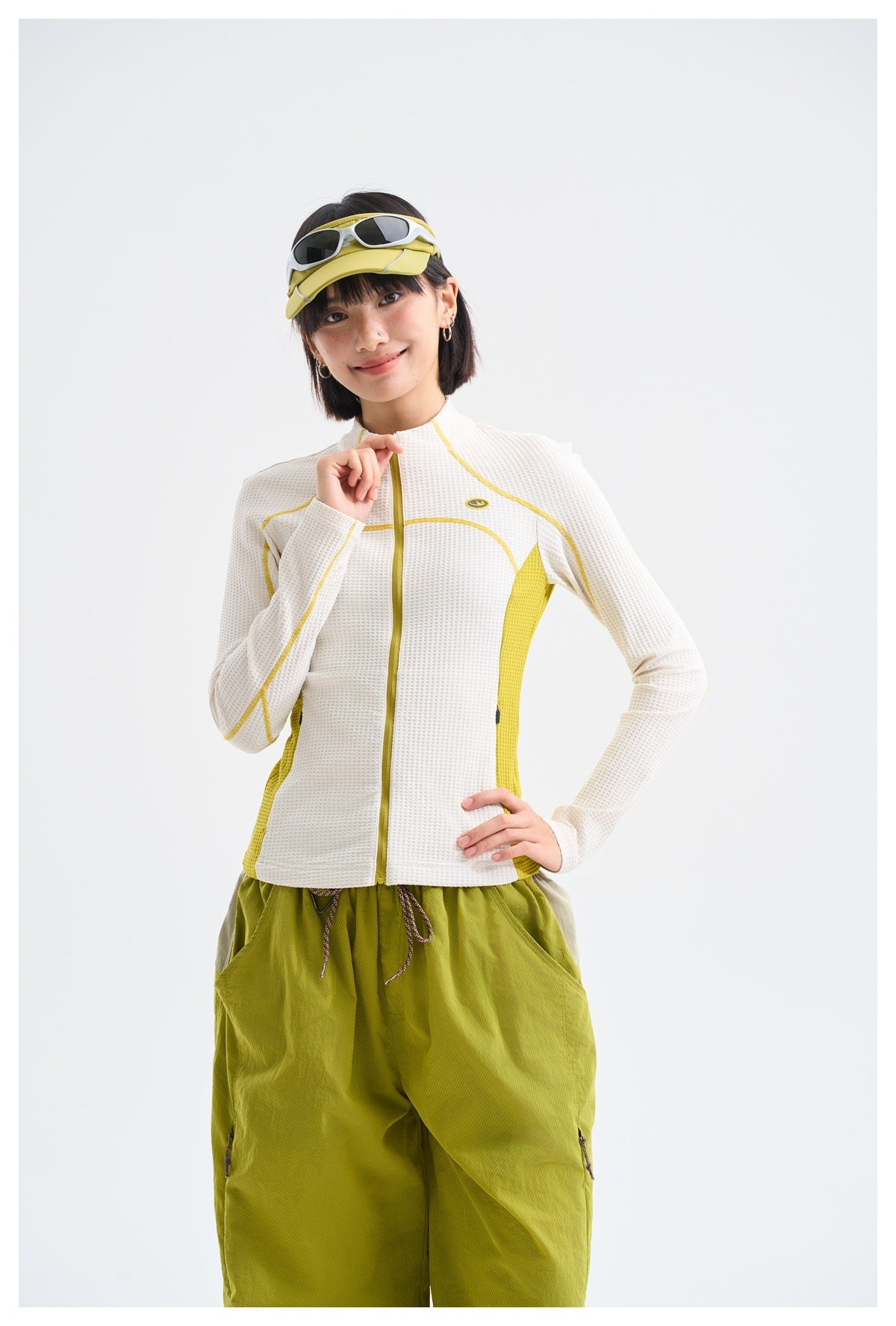 Model wearing a white textured zip-front jacket with yellow accents, shown from the front.
