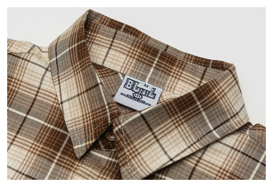 Close-up of a brown, tan and cream plaid shirt collar with a visible sewn-in neck label.