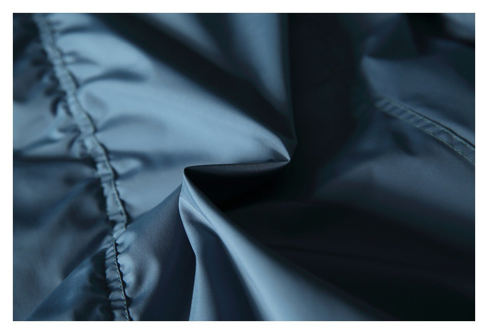 Close-up of smooth blue-gray jacket fabric folded to show seams and texture.