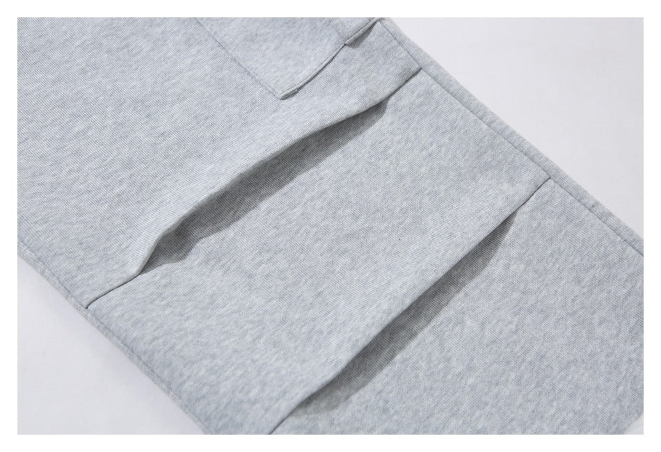 Close-up of stitched panel seams on the leg of light gray heathered pants.