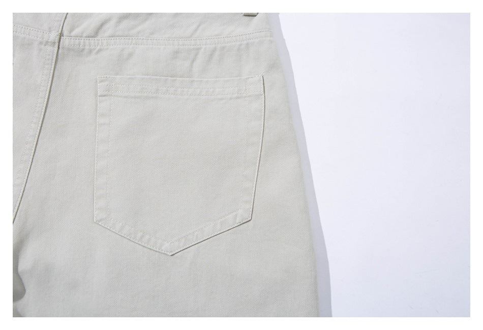 Close-up of light beige trousers showing a stitched back pocket and waistband.