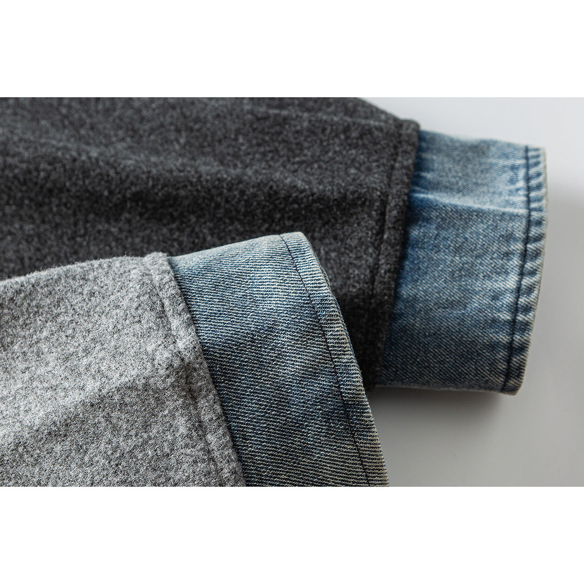 Close-up of a gray jacket sleeve turned back to reveal its blue denim cuff lining.