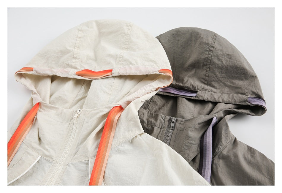Close-up of ivory and gray jacket hoods, showing contrasting trim and front zippers.