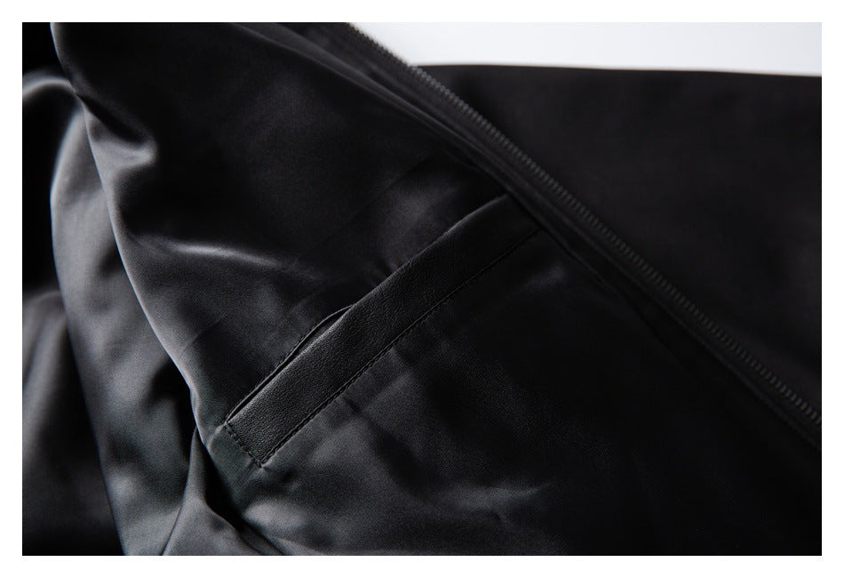 Close-up of a black jacket's diagonal pocket opening beside its zipper.