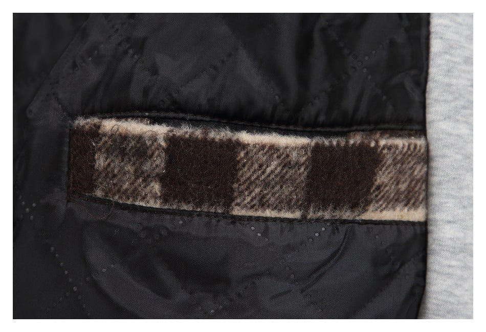 Close-up of black garment lining with a horizontal strip of brown and beige plaid trim.