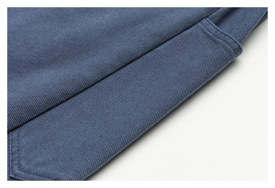 Close-up of a blue-gray trouser leg hem with visible twill texture and stitching.