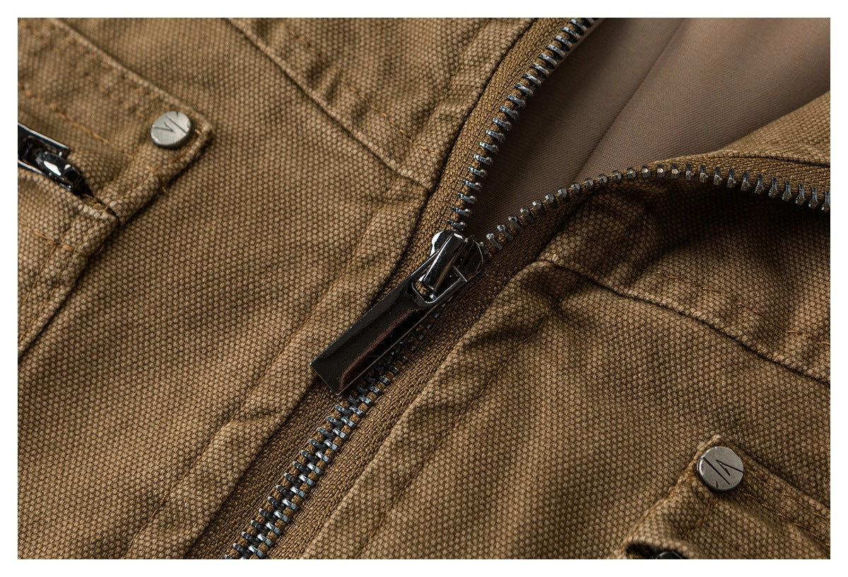 Close-up of a brown textured garment with a metal zipper, snap buttons, and stitched panels.