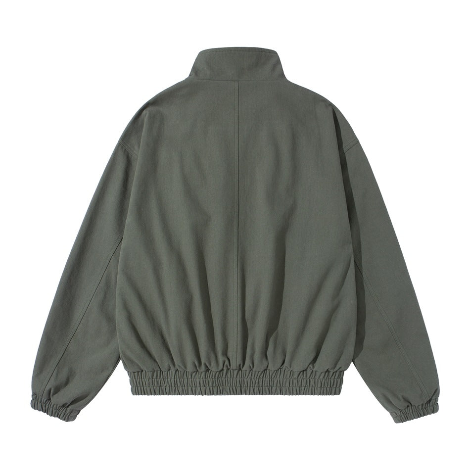 Back view of army green jacket with center seam, stand collar, elastic hem and elastic cuffs, flat lay