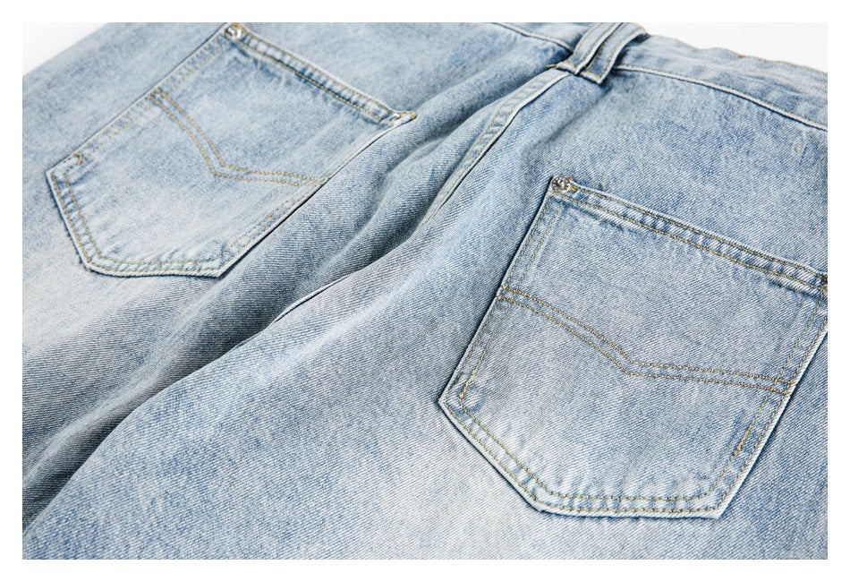 Light blue jeans laid flat, showing two back pockets and the waistband.