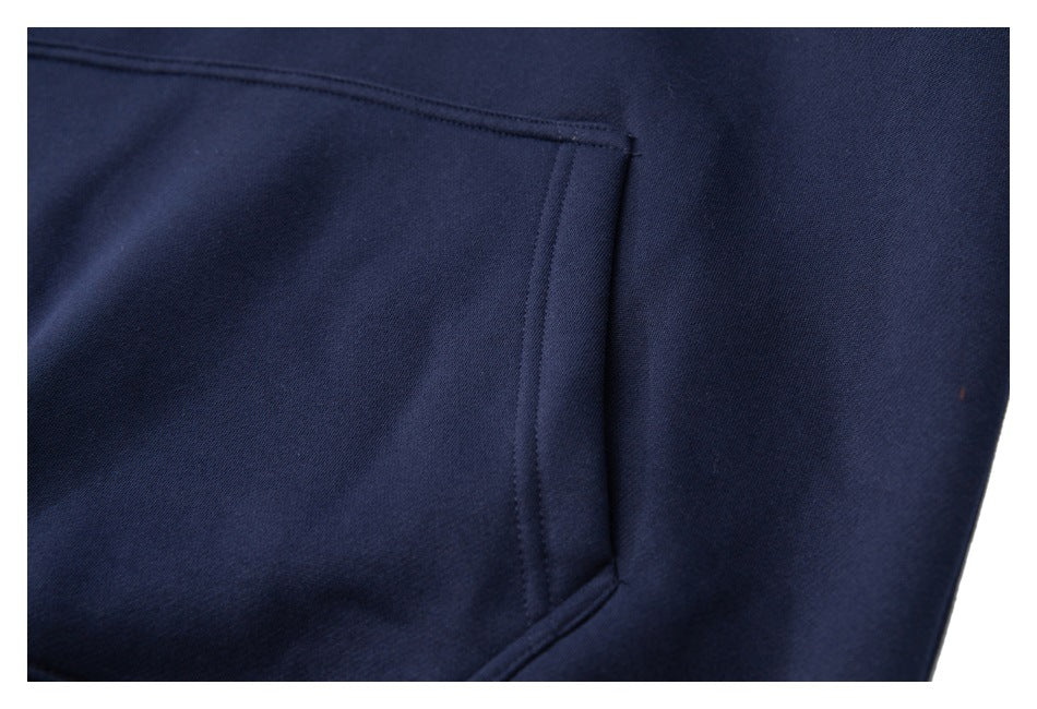 Close-up of a navy garment's stitched pocket opening and fabric.
