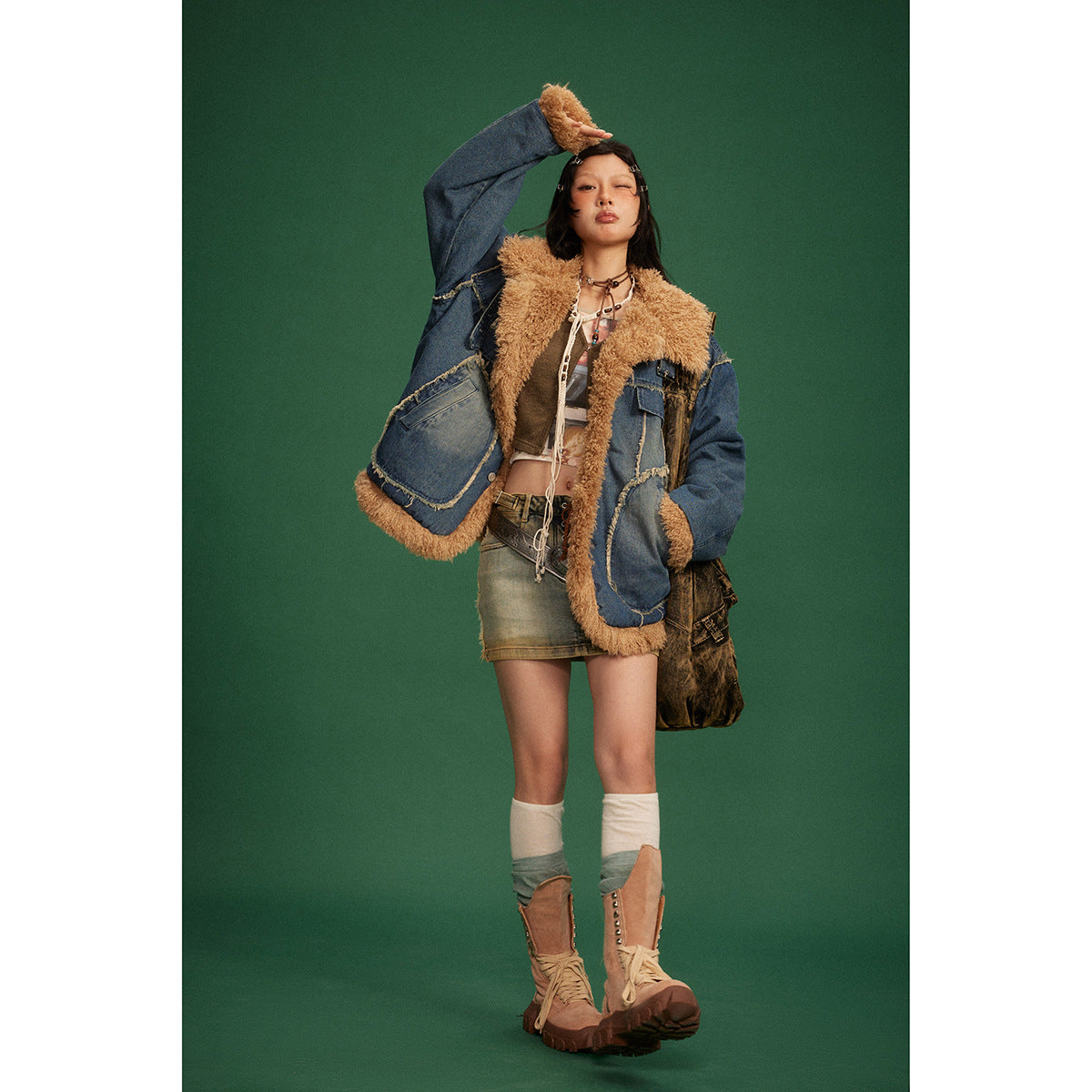 Full-length model wearing an open blue denim jacket with tan shaggy trim and oversized pockets.