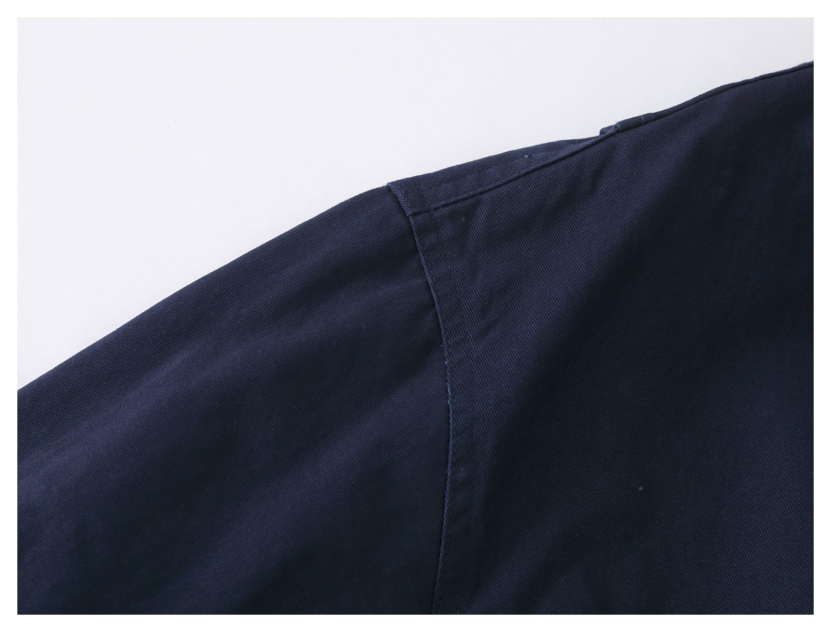 Close-up of the dark navy jacket's shoulder and sleeve seam.
