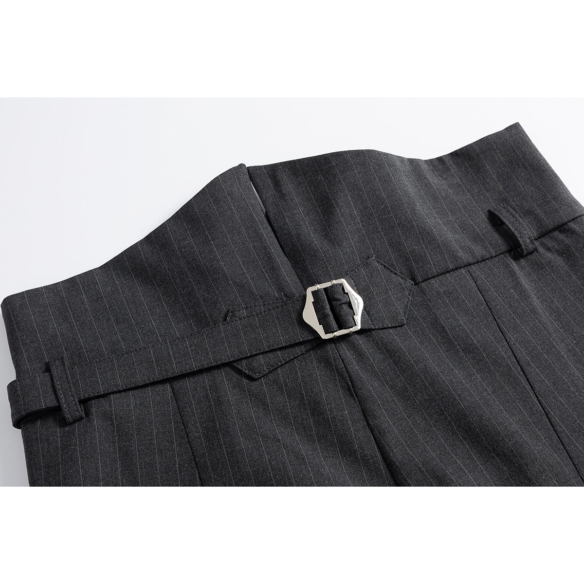 Close-up of the back waistband of charcoal pinstripe trousers with belt loops and a silver buckle.
