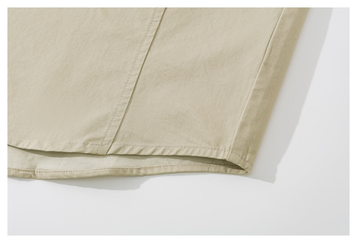 Close-up of the stitched bottom hem of a beige shirt.