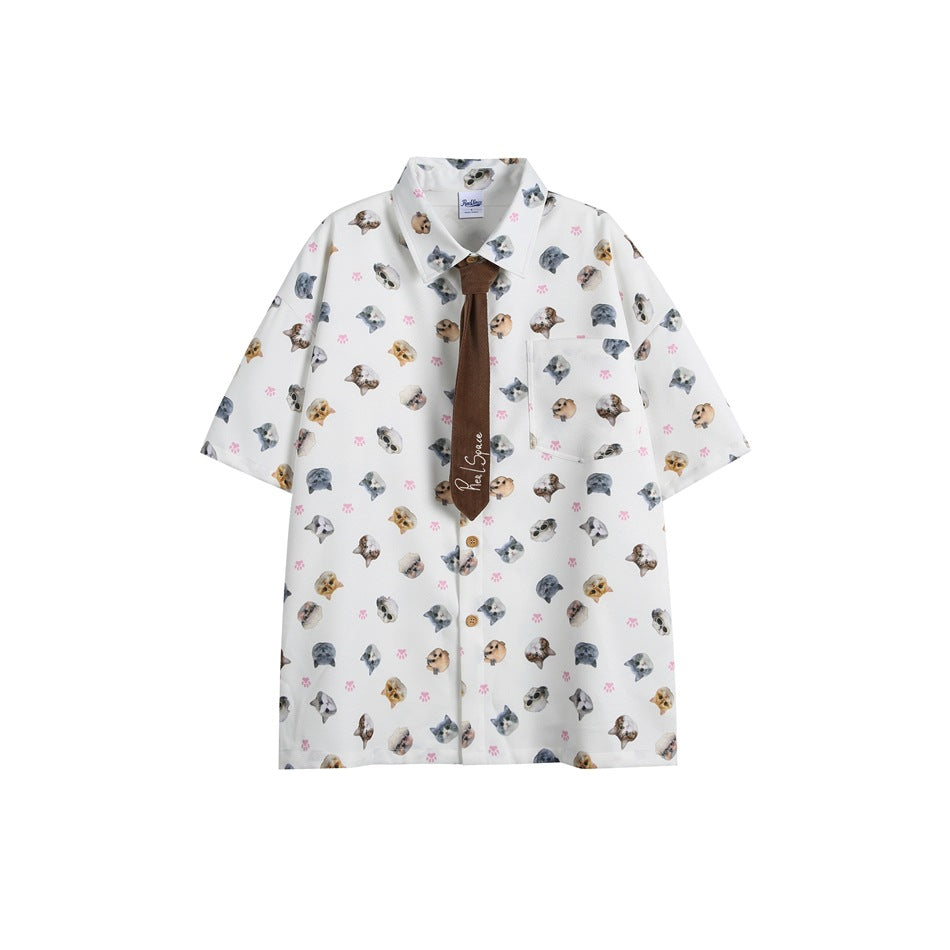 White short-sleeve shirt with all-over cat face and paw print, chest pocket and brown tie, flat front view