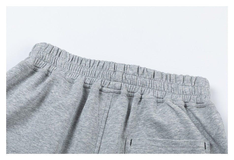 Close-up of the elastic waistband and rear pocket area of light gray heathered shorts.
