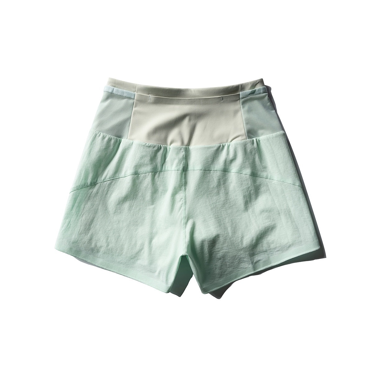 Mint green shorts with a pale waistband and textured lower panels, shown from the front.