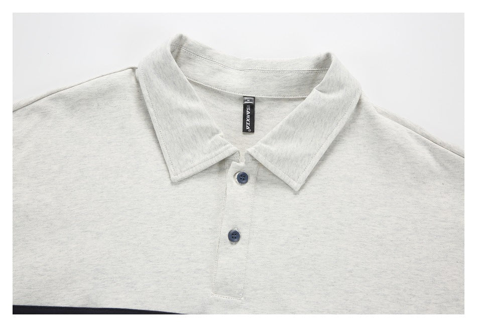 Upper front of a light gray heather polo shirt with a pointed collar and two dark buttons.