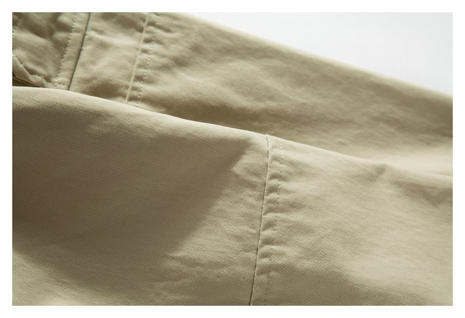 Close-up of beige garment fabric with stitched panel seams and a folded section.