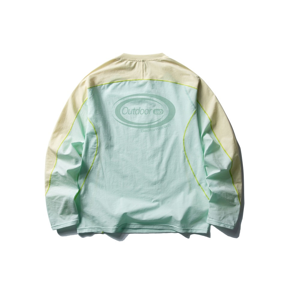 Back of a mint and pale yellow long-sleeve top with lime contrast seams and a large back logo.