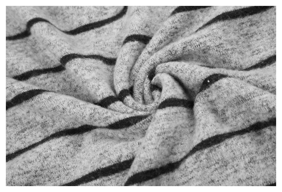Close-up of gray knit fabric with black stripes gathered into folds.