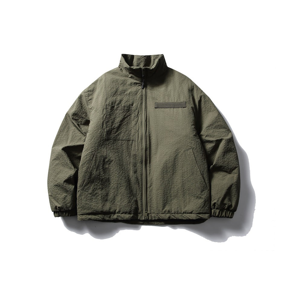 Olive green stand-collar zip jacket with textured surface, chest patch and pockets, flat front view
