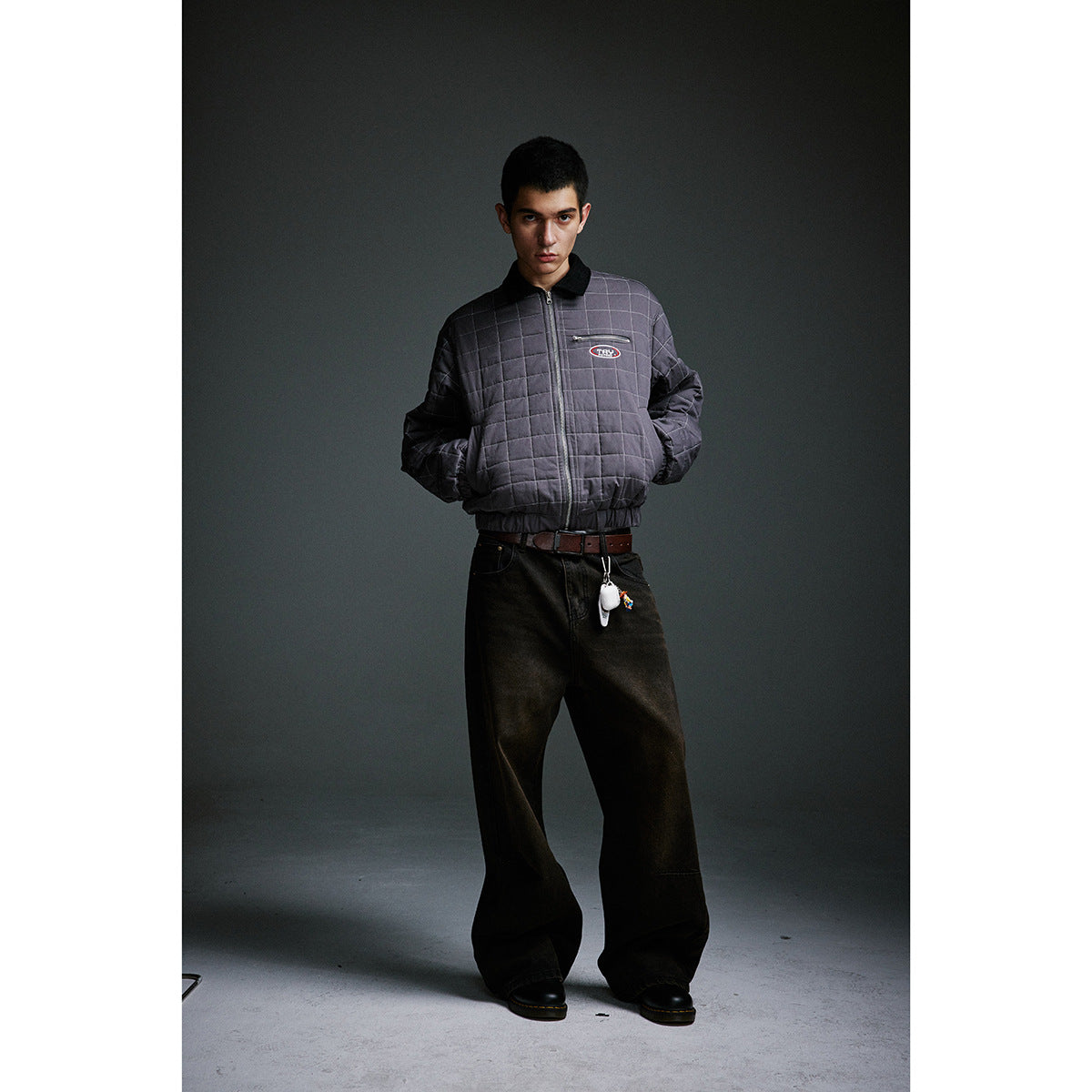 Full-length model in a charcoal gray quilted jacket with a black collar, zip front and chest pocket.