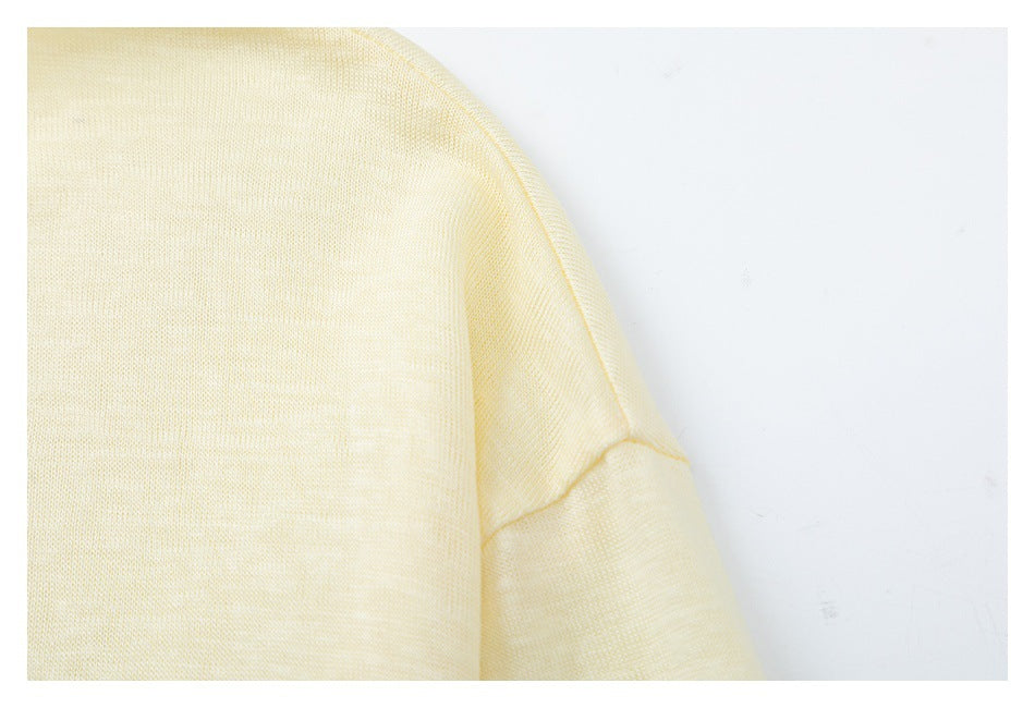 Close-up of the pale cream shirt's shoulder and sleeve seam.