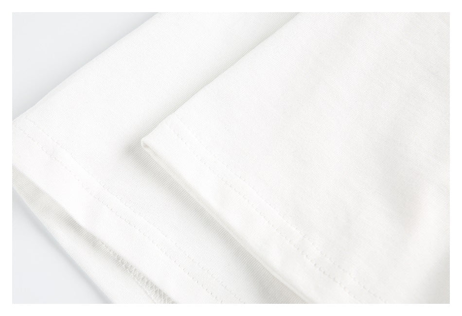 Close-up of white garment fabric with a stitched hem and folded seam.