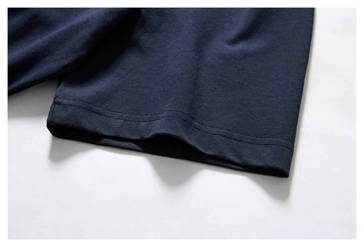 Close-up of the stitched hem on a plain navy garment against a white background.