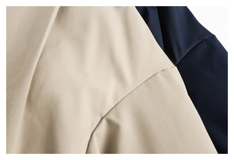 Close-up of ribbed beige outerwear fabric overlapping a dark navy garment.