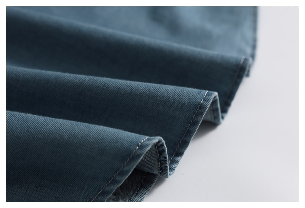 Close-up of folded blue denim garment edges with contrasting seam stitching.