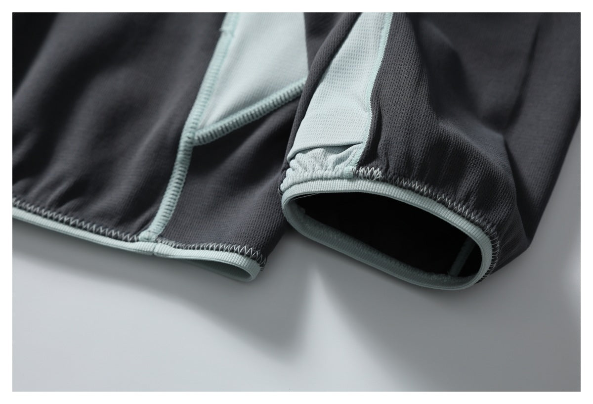 Close-up of the charcoal pullover's pale mint cuff and bound seam stitching.